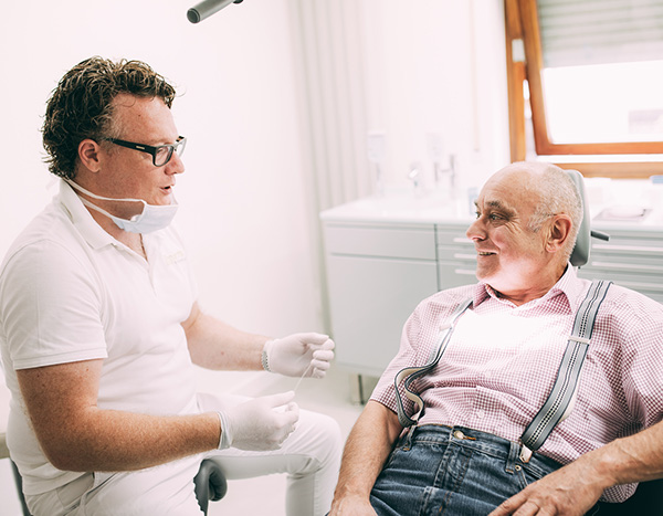 Implantate - Dr. Pfitzer spricht mit einem Patienten in der Zahnarztpraxis Dr. Pfitzer in Stuttgart