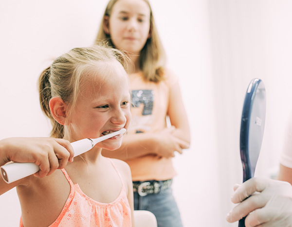 Zahnwissen - Eine junge Patientin lernt unter Anleitung von Dr. Pfitzer wie man Zähne putzt in der Zahnarztpraxis Dr. Pfitzer in Stuttgart
