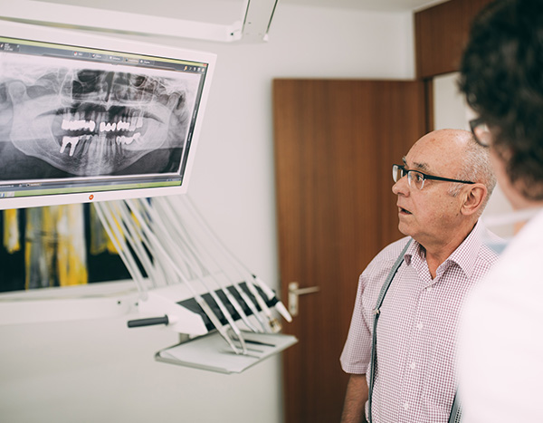 Parodontitis - Patient begutachtet Röntgenaufnahme in der Zahnarztpraxis Dr. Pfitzer in Stuttgart